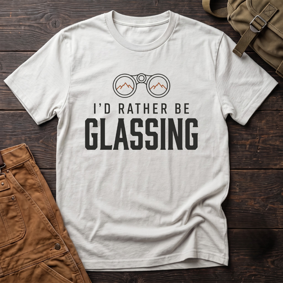 White hunting t-shirt with I'd Rather Be Glassing text and binoculars with mountains in the lenses