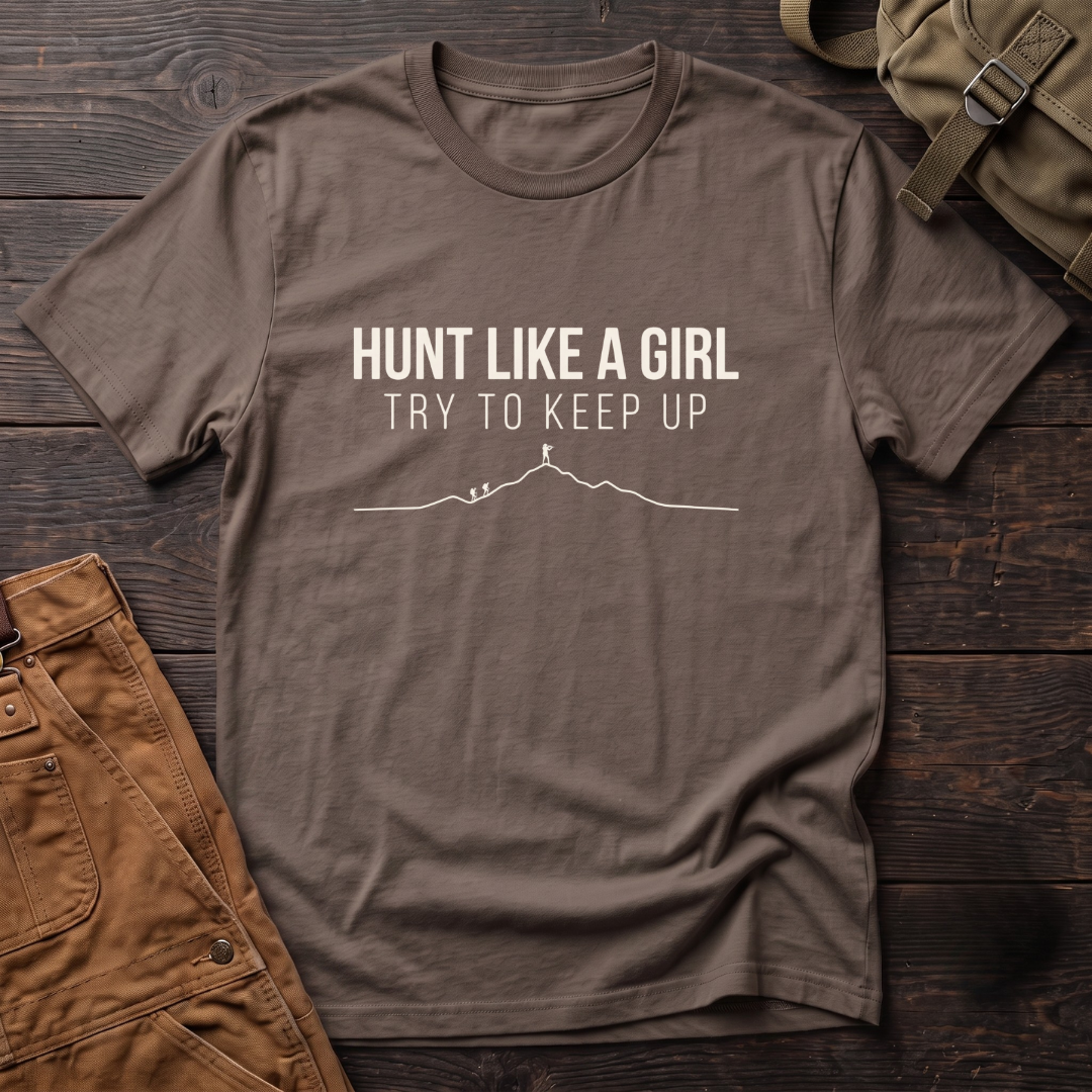 Brown women's hunting t-shirt with Hunt Like A Girl, Try To Keep Up text and a line-art mountain ridge with a hunter on the summit ahead of two hikers