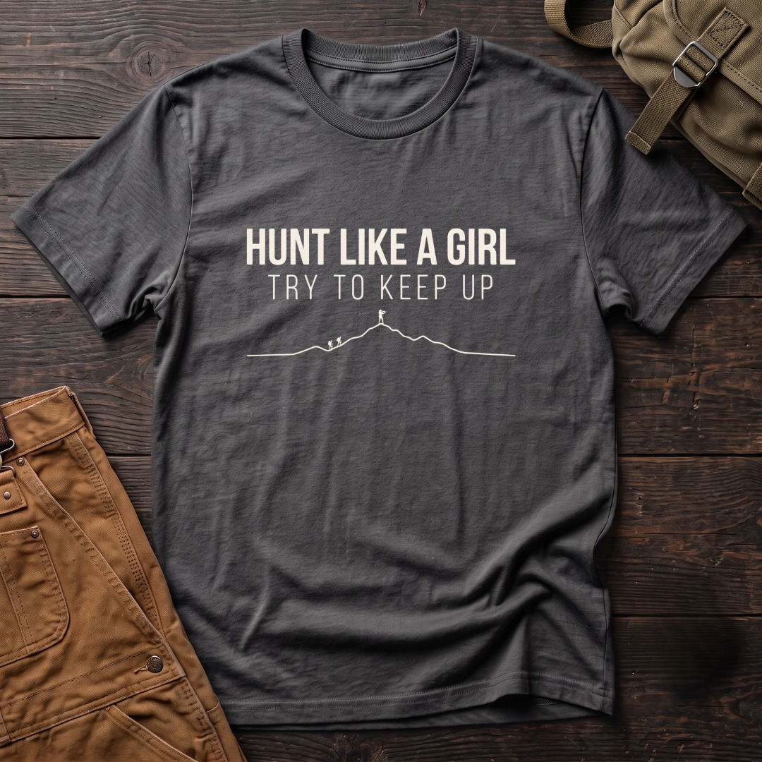 Asphalt women's hunting t-shirt with Hunt Like A Girl, Try To Keep Up text and a line-art mountain ridge with a hunter on the summit ahead of two hikers
