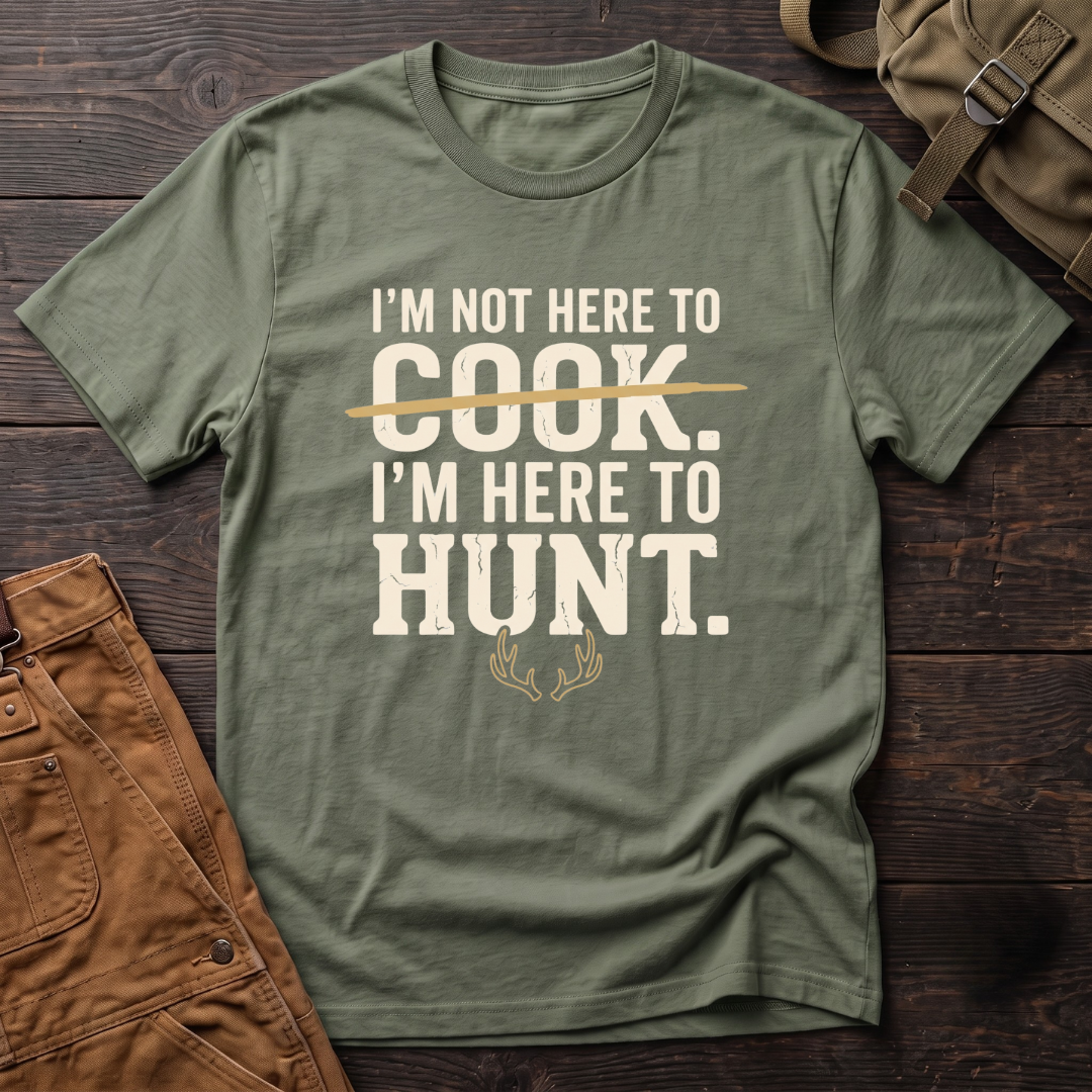 Military Green funny hunting t-shirt with I'm Not Here To Cook, I'm Here To Hunt text, the word Cook crossed out, and a pair of antlers