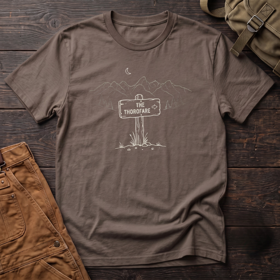 Brown Wyoming backcountry t-shirt with The Thorofare trail sign under a line-art mountain range, pine trees and a crescent moon