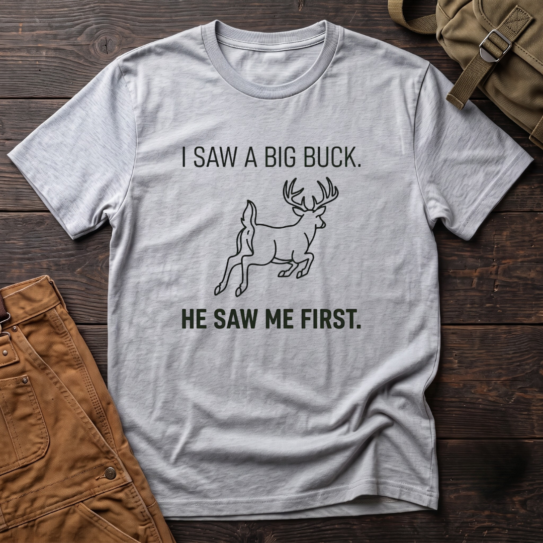 Athletic Heather funny deer hunting t-shirt with I Saw A Big Buck, He Saw Me First text and a line-art whitetail buck bounding away
