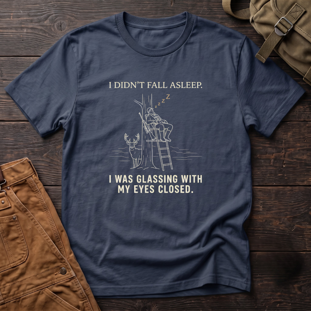 Navy funny deer hunting t-shirt with I Didn't Fall Asleep, I Was Glassing With My Eyes Closed text and a line-art hunter dozing in a ladder stand while a whitetail buck stands below