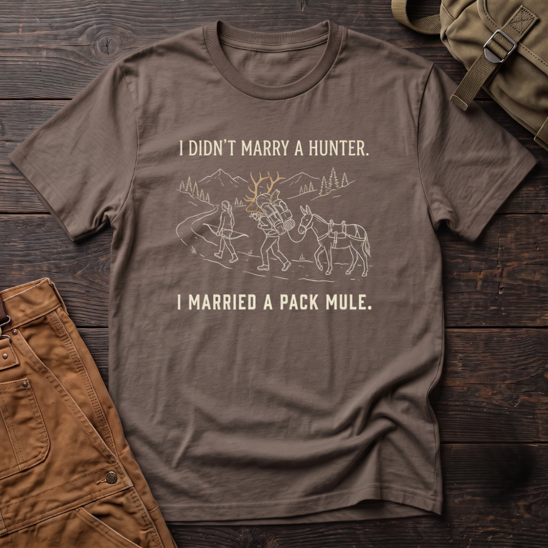 Brown funny hunting t-shirt with I Didn't Marry A Hunter, I Married A Pack Mule text and a line-art bowhunter walking ahead of a partner who packs out an elk rack, next to a pack mule