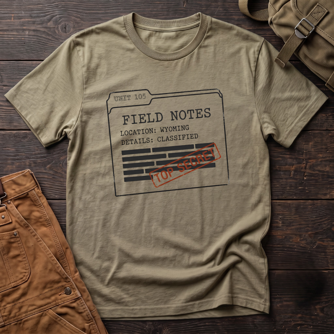 Heather Olive funny hunting t-shirt with a Unit 105 Field Notes folder, Location: Wyoming, Details: Classified, redacted lines and a Top Secret stamp