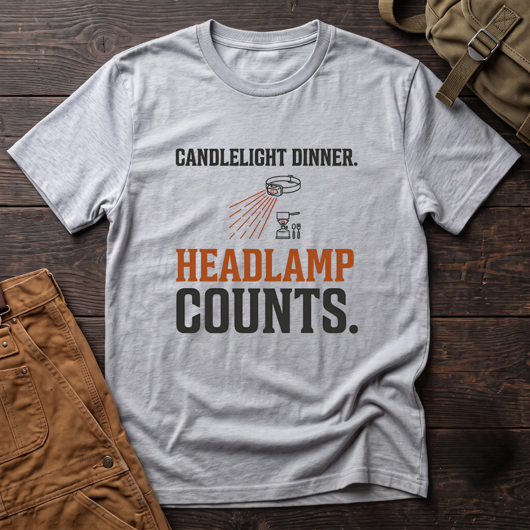 Athletic Heather funny hunting t-shirt with Candlelight Dinner. Headlamp Counts. text and a headlamp shining on a camp stove