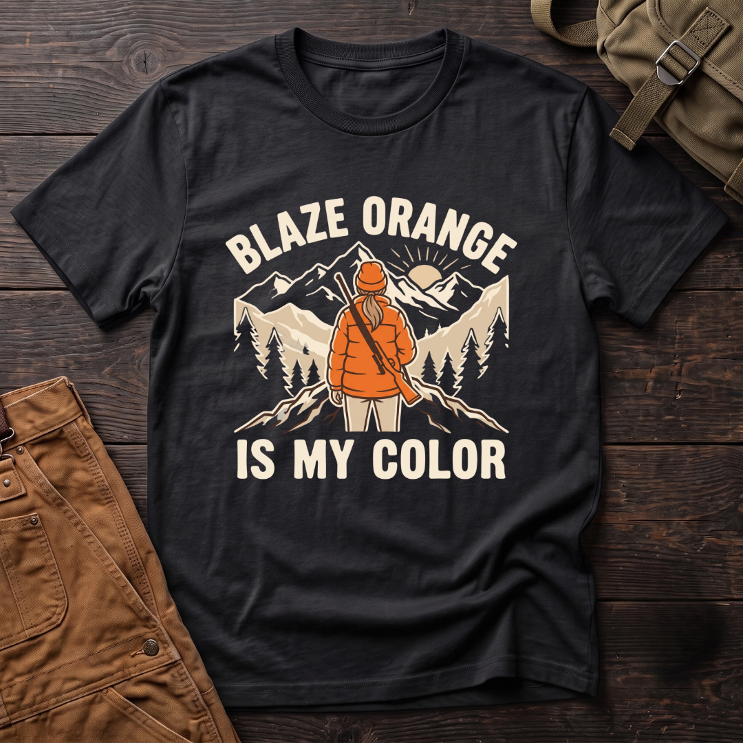 Black women's hunting t-shirt with Blaze Orange Is My Color lettering and a woman hunter in blaze orange with a rifle facing a mountain sunrise