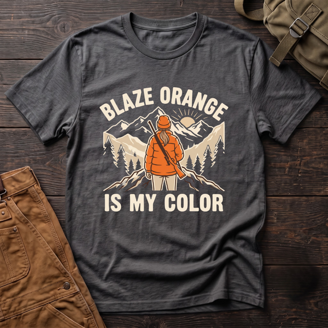 Asphalt women's hunting t-shirt with Blaze Orange Is My Color lettering and a woman hunter in blaze orange with a rifle facing a mountain sunrise