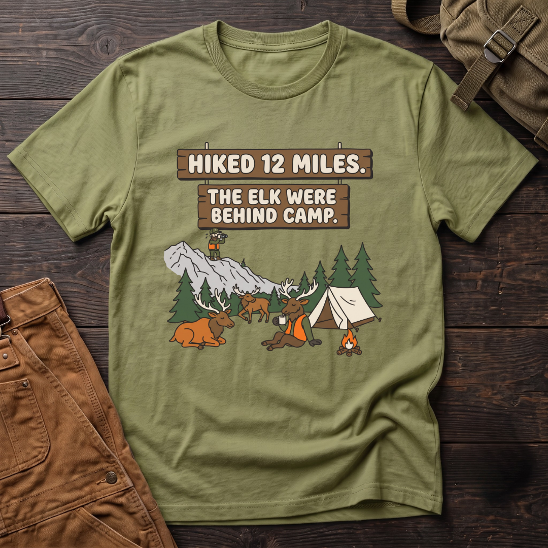 Heather Green funny elk hunting t-shirt with Hiked 12 Miles. The Elk Were Behind Camp. signs and elk walking past a tent while the hunter glasses far away