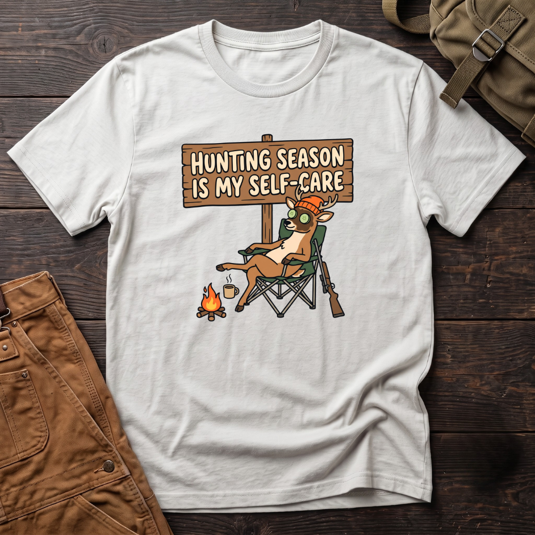 White funny women's hunting t-shirt with a Hunting Season Is My Self-Care sign and a relaxed deer in a camp chair with a cucumber eye mask and coffee