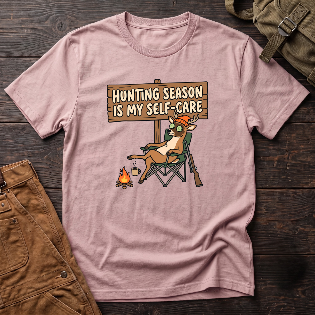 Pink funny women's hunting t-shirt with a Hunting Season Is My Self-Care sign and a relaxed deer in a camp chair with a cucumber eye mask and coffee