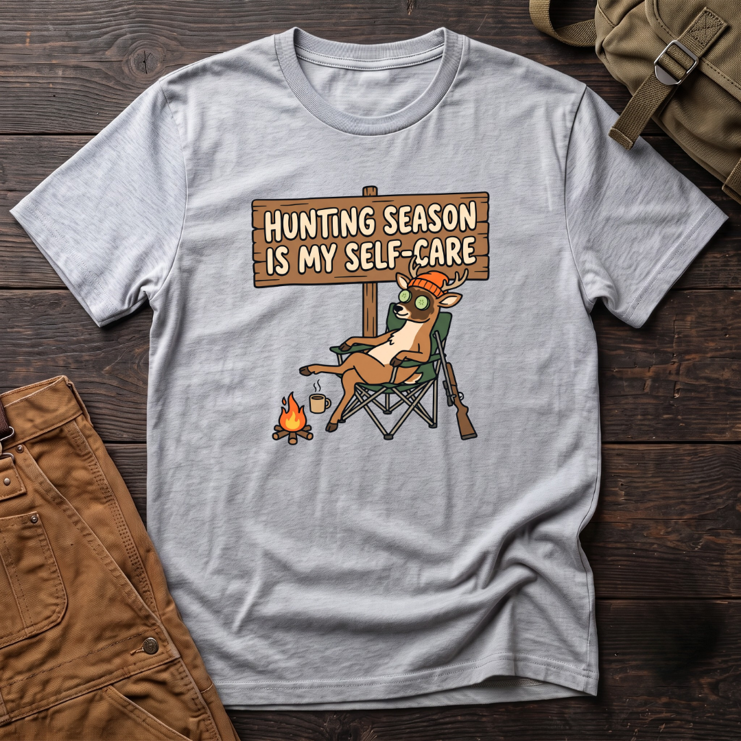 Athletic Heather funny women's hunting t-shirt with a Hunting Season Is My Self-Care sign and a relaxed deer in a camp chair with a cucumber eye mask and coffee