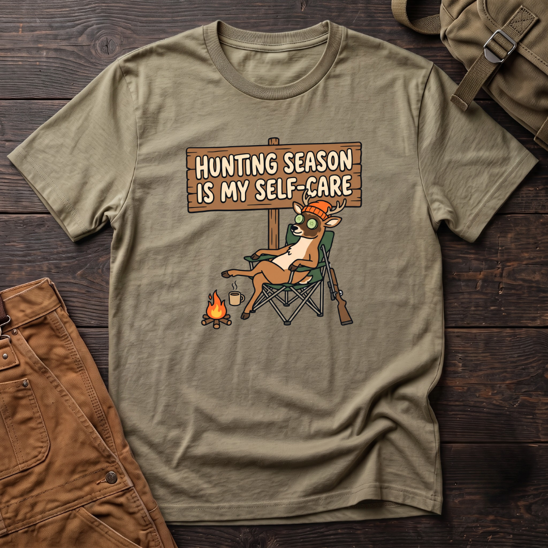 Heather Olive funny women's hunting t-shirt with a Hunting Season Is My Self-Care sign and a relaxed deer in a camp chair with a cucumber eye mask and coffee