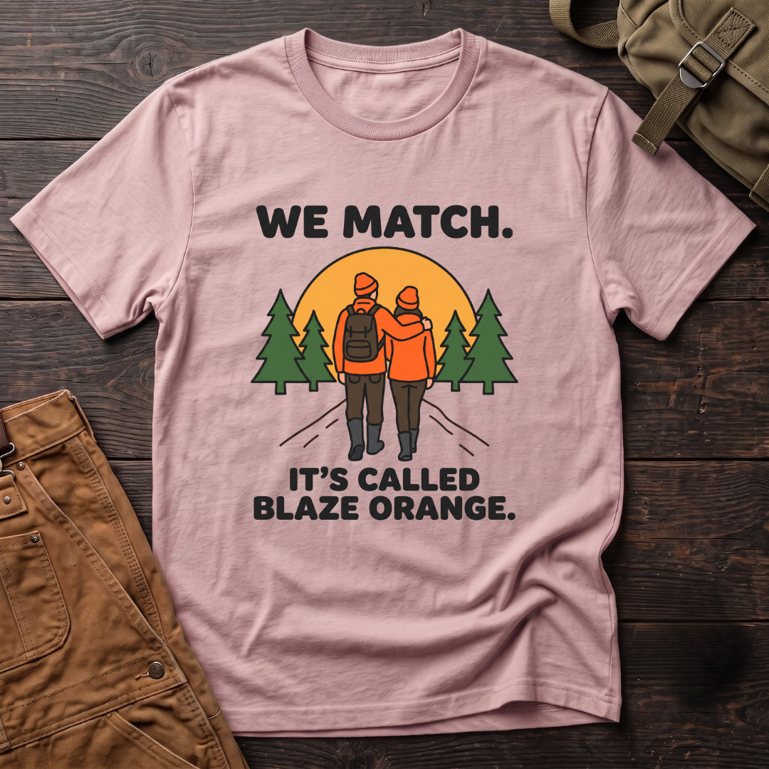 Pink funny hunting couple t-shirt with We Match. It's Called Blaze Orange. text and a hunting couple in blaze orange walking toward a sunset between pine trees