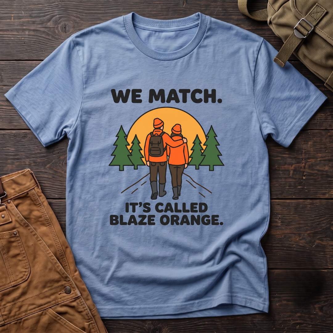 Heather Columbia Blue funny hunting couple t-shirt with We Match. It's Called Blaze Orange. text and a hunting couple in blaze orange walking toward a sunset between pine trees