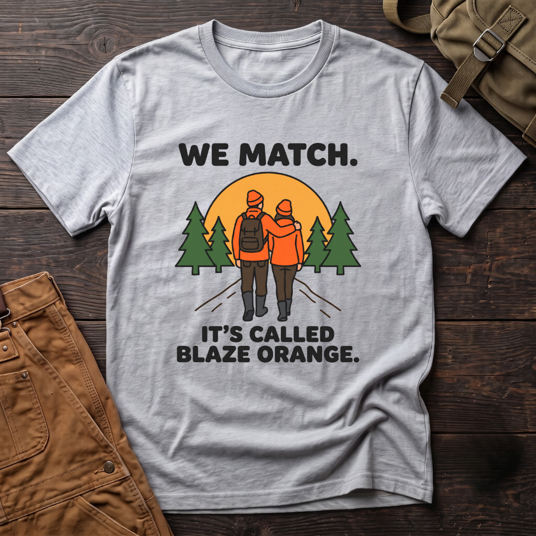 Athletic Heather funny hunting couple t-shirt with We Match. It's Called Blaze Orange. text and a hunting couple in blaze orange walking toward a sunset between pine trees