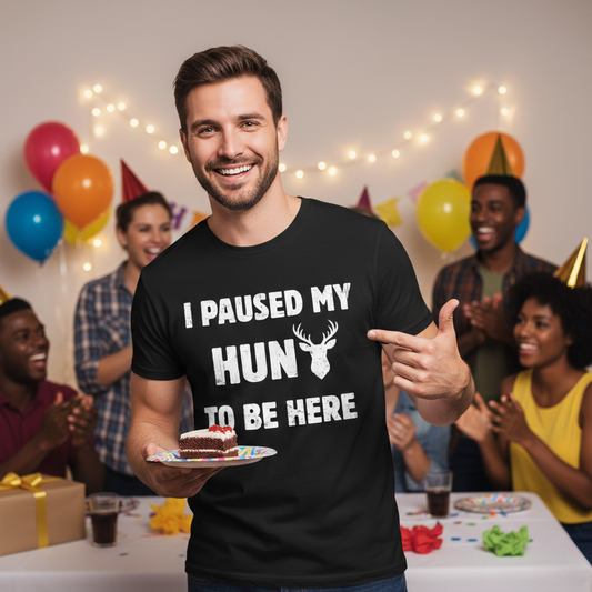 Man at a birthday party wearing the I Paused My Hunt to Be Here deer hunting t-shirt, smiling and pointing at the graphic while holding a slice of cake.